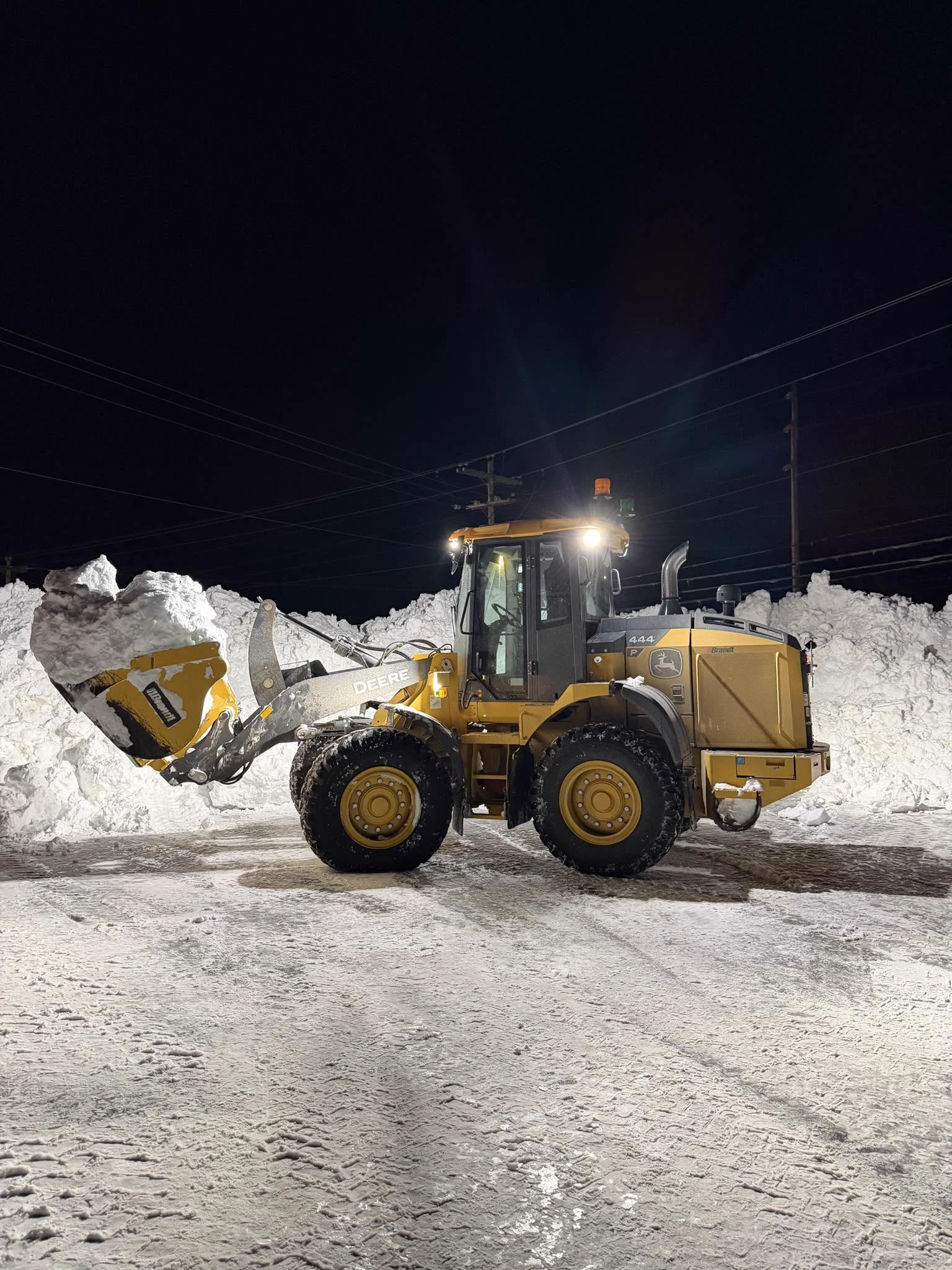 LBA loader working beside a large snowbank at night